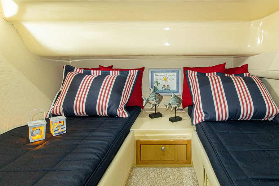 No segundo quarto, as duas camas de solteiro foram trabalhadas com roupas de cama sob medida da M. Decor em tons de azul e vermelho, em estilo náutico