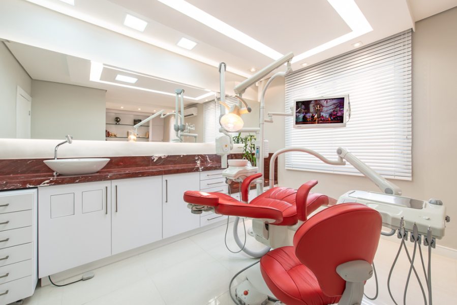 A cadeira odontológica Gnatus Inova New, com kit multimídia, recebeu couro vermelho que combina com a bancada de mármore