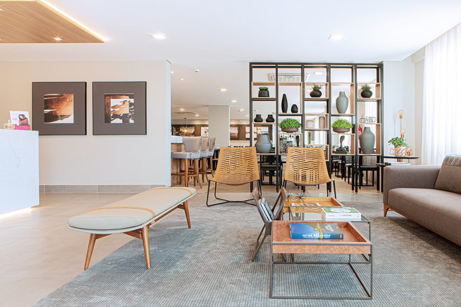 O lounge da recepção é composto por móveis de design brasileiro (M.  Decor) como as poltronas Yan, em metal e couro natural, além de uma estante com nichos vazados que conecta discretamente o espaço da área do restaurante