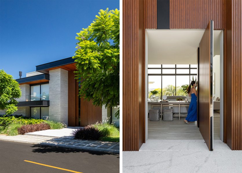 A entrada principal da casa é marcada por uma porta pivotante em ACM, com acabamento especial que combina pintura preta brilhante e detalhes que simulam a textura da madeira.