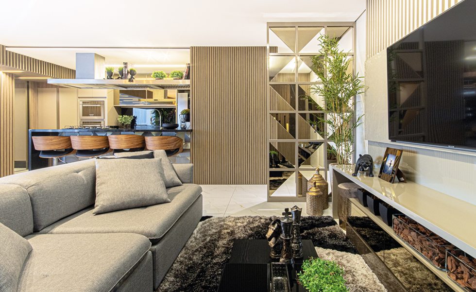 Um painel de marcenaria feito sob medida, com detalhes vazados e espelhos, delimitam o hall de entrada, separando-o do home theater. Os móveis soltos são da Inove Design Um painel de marcenaria feito sob medida, com detalhes vazados e espelhos, delimitam o hall de entrada, separando-o do home theater. Os móveis soltos são da Inove Design