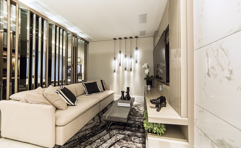 living com home theater recebeu cinco pendentes posicionados próximos à parede, com visual escultural. O luminotécnico (Spot Lighting) faz uso de barras contínuas de LED em detalhes no gesso e no mobiliário, criando soltura living com home theater recebeu cinco pendentes posicionados próximos à parede, com visual escultural. O luminotécnico (Spot Lighting) faz uso de barras contínuas de LED em detalhes no gesso e no mobiliário, criando soltura