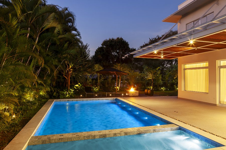 Iluminações embutidas diretamente nas paredes ou no fundo da piscina estão em alta. Elas proporcionam uma estética limpa e moderna, além de destacar o design durante a noite. Projeto: Infinity Spaces Arquitetura e Interiores. | Foto: Dotta Photo