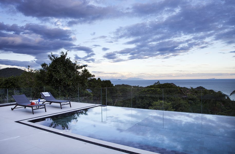 Aqui a proposta do guarda-corpo de vidro foi proteger de quedas e permitir a visão plena da paisagem. Projeto: Infinity Spaces Arquitetura e Interiores Foto: Dotta Photo