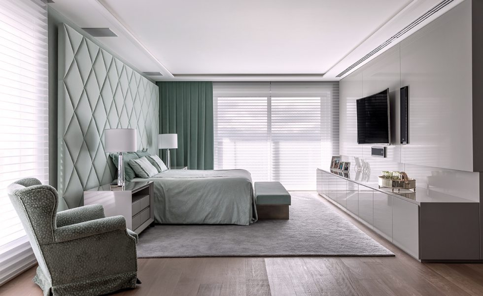 Na suíte máster, painel de cabeceira em veludo no mesmo tom das cortinas e móveis soltos. A iluminação é indireta, para criar um cenário acolhedor, e conta ainda com dois abajures decorativos nas laterais da cama. O painel da TV foi feito sob medida pela Marcenaria Móveis Mota e executado em laca brilhante Na suíte máster, painel de cabeceira em veludo no mesmo tom das cortinas e móveis soltos. A iluminação é indireta, para criar um cenário acolhedor, e conta ainda com dois abajures decorativos nas laterais da cama. O painel da TV foi feito sob medida pela Marcenaria Móveis Mota e executado em laca brilhante