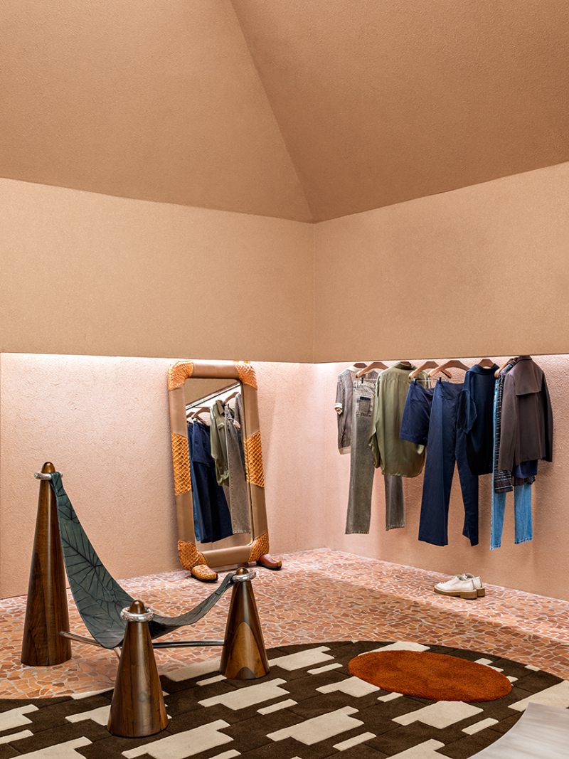 Diálogo entre moda e design nacional: o ambiente integra peças icônicas como a poltrona Pilão — fruto da colaboração entre a MISCI e o Estúdio Orth —, unindo referências culturais e materiais genuínos.