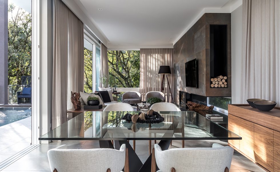 O living e sala de jantar são amplamente integrados entre si e com a área externa. Todos os móveis ? cadeiras de jantar, buffet, poltronas, mesas de centro e mesas laterais ? foram escolhidas cuidadosamente na Momenttum. A estrutura em steel frame que abriga a lareira foi revestida em porcelanato Corten (Portobello shop), que imita a rusticidade do aço enferrujado. Grandes aberturas com esquadrias de PVC da Weiku proporcionam iluminação natural abundante O living e sala de jantar são amplamente integrados entre si e com a área externa. Todos os móveis ? cadeiras de jantar, buffet, poltronas, mesas de centro e mesas laterais ? foram escolhidas cuidadosamente na Momenttum. A estrutura em steel frame que abriga a lareira foi revestida em porcelanato Corten (Portobello shop), que imita a rusticidade do aço enferrujado. Grandes aberturas com esquadrias de PVC da Weiku proporcionam iluminação natural abundante