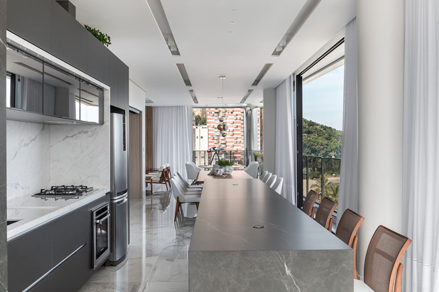 O espaço gourmet integrado à sala de jantar ganhou armários sob medida em MDF cinza chumbo (Deco Marcenaria) e mármore Branco Paraná (Michelangelo). O luminotécnico foi trabalhado a partir de rasgos no forro de gesso com iluminação embutida (Grey House Iluminação).