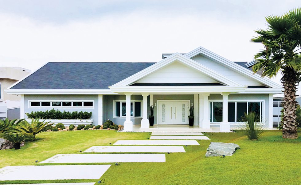 A casa em estilo neoclássico foi implantada em um terreno espaçoso. É térrea, com espaços integrados voltados para a área de lazer e convívio por meio de amplas aberturas em PVC (Europa Esquadrias de PVC) A casa em estilo neoclássico foi implantada em um terreno espaçoso. É térrea, com espaços integrados voltados para a área de lazer e convívio por meio de amplas aberturas em PVC (Europa Esquadrias de PVC)