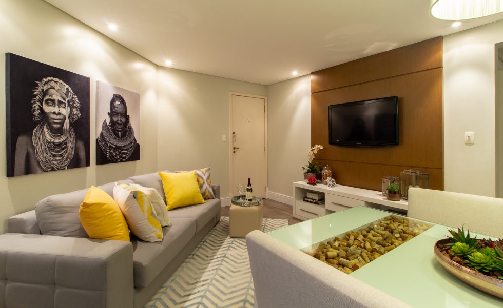 A sala de estar recebeu impressões em suede, da Bali Design, sofá da Piccola Brotto, com revestimento resistente e cor neutra, e tapete da Casanova Interiores. O painel da TV é em linheiro dourado e branco e com iluminação pontual