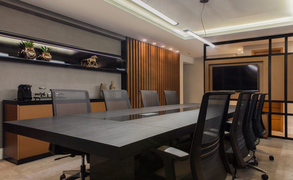 Na sala de reuniões, o forro de gesso ganhou rebaixo para criar uma atmosfera mais intimista e acolhedora. Todo o mobiliário foi desenhado pelo escritório e executado em marcenaria. A mesa em MDF preto fosco tem o centro em MDF preto brilho, tomadas embutidas e base inferior removível para fácil acesso à fiação Na sala de reuniões, o forro de gesso ganhou rebaixo para criar uma atmosfera mais intimista e acolhedora. Todo o mobiliário foi desenhado pelo escritório e executado em marcenaria. A mesa em MDF preto fosco tem o centro em MDF preto brilho, tomadas embutidas e base inferior removível para fácil acesso à fiação