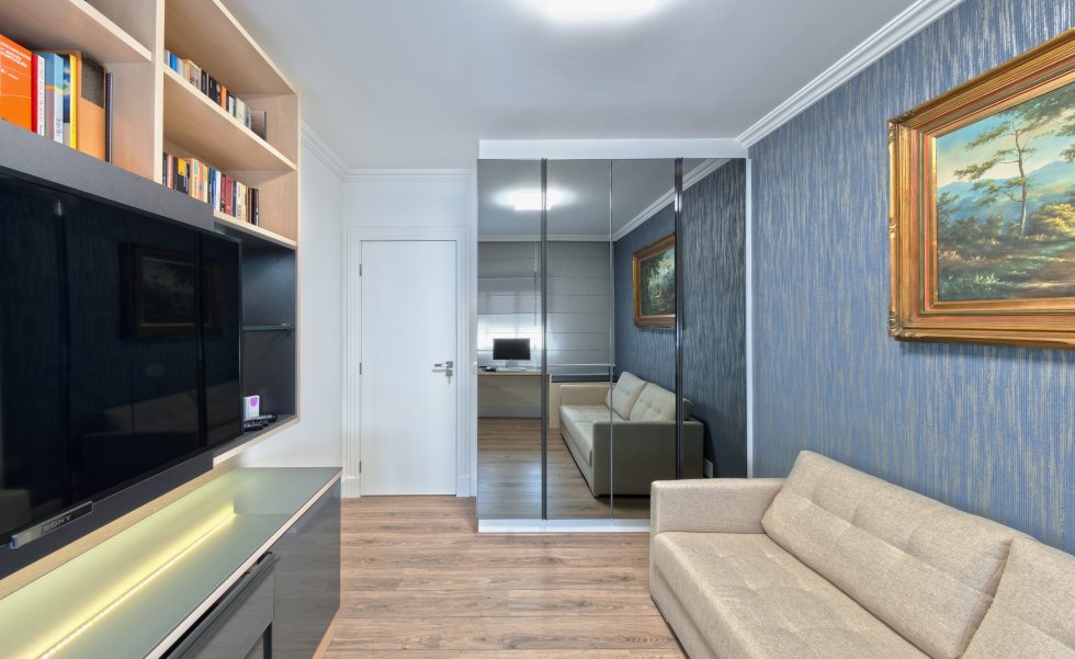 A sala de TV recebeu papel de parede e móveis reformados, mais adequados ao novo estilo do espaço.