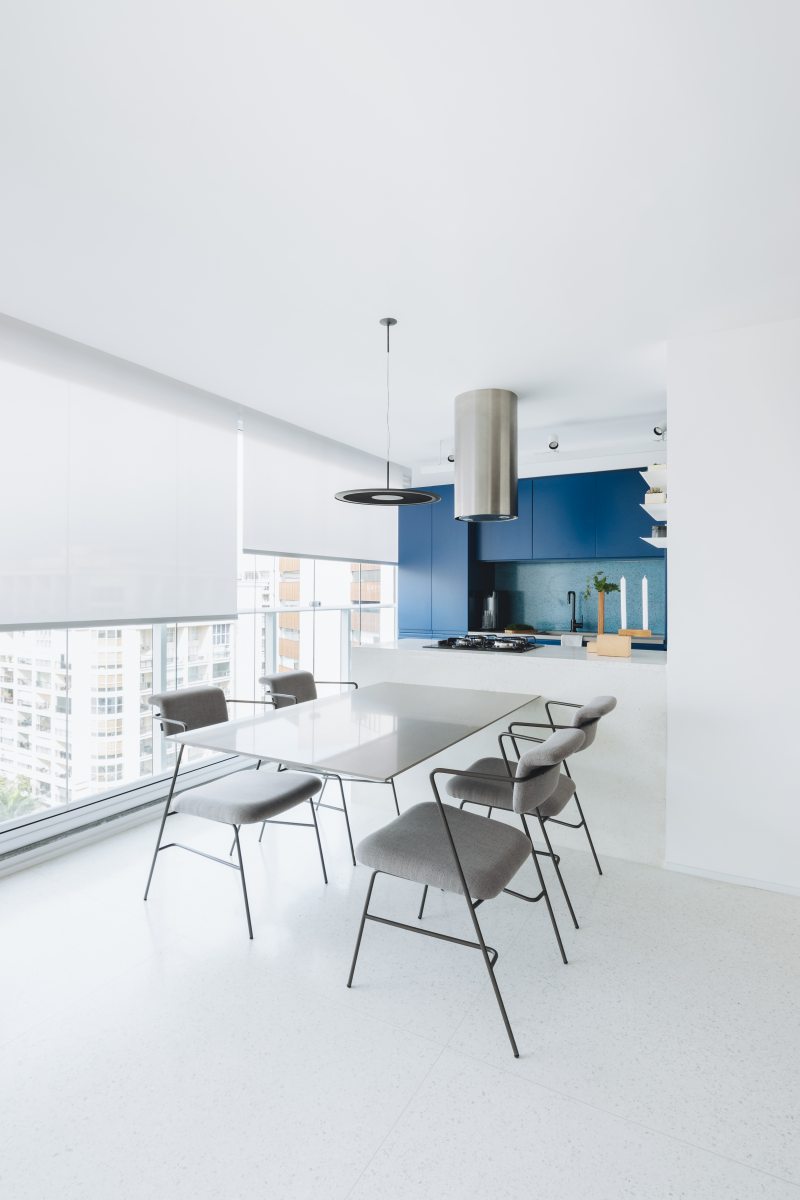 O ambiente claro evidencia o volume azul ao fundo. A cor se concentra e define a &aacute;rea da cozinha. Projeto: Rawi Arquitetura Foto: Juliana Deeke