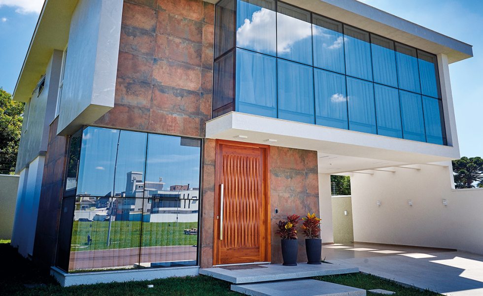 ara a fachada, structural glazing com vidros Habitat Prata (Europa Esquadrias de PVC). A construção e execução são da TAS Engenharia. No restante da casa, esquadrias brancas em grandes formatos, com vidros incolores