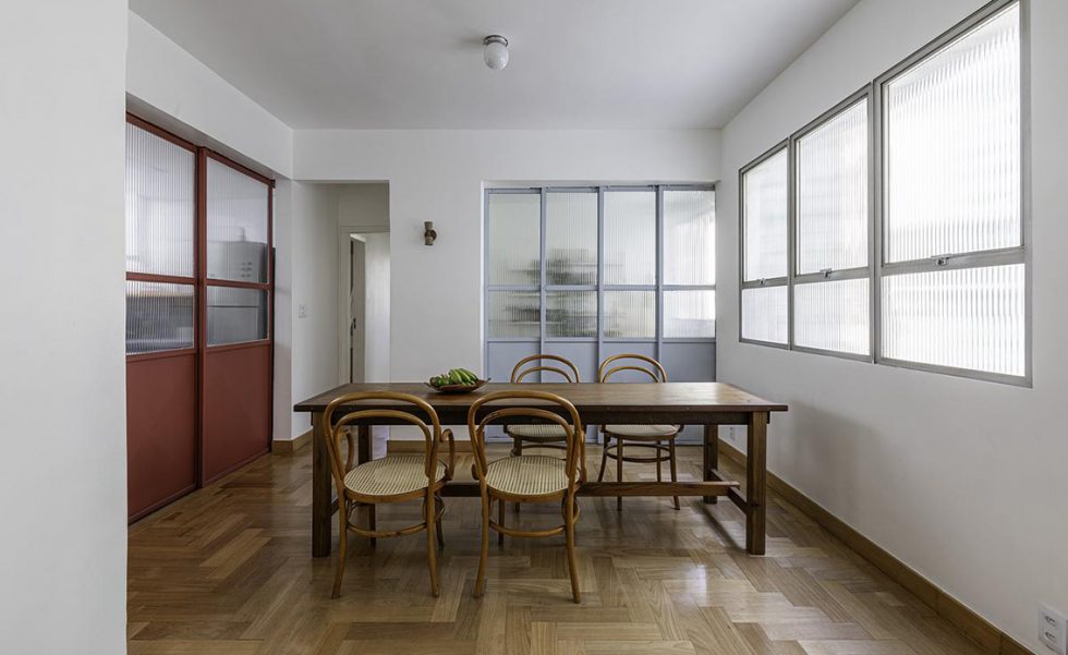 O vidro canelado está presente nas portas metálicas que separam os ambientes. Para evitar monotonia visual o truque foi o uso de duas cores contrastantes, o vermelho e o azul. 