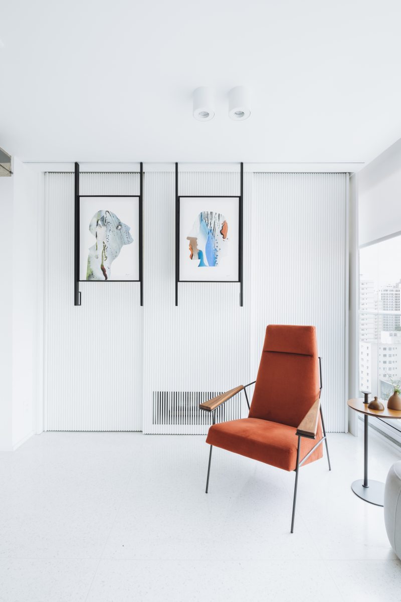 A parede neutra destaca o desenho da poltrona. O terracota aparece com mais intensidade no ambiente. Projeto: Rawi Arquitetura Foto: Juliana Deeke