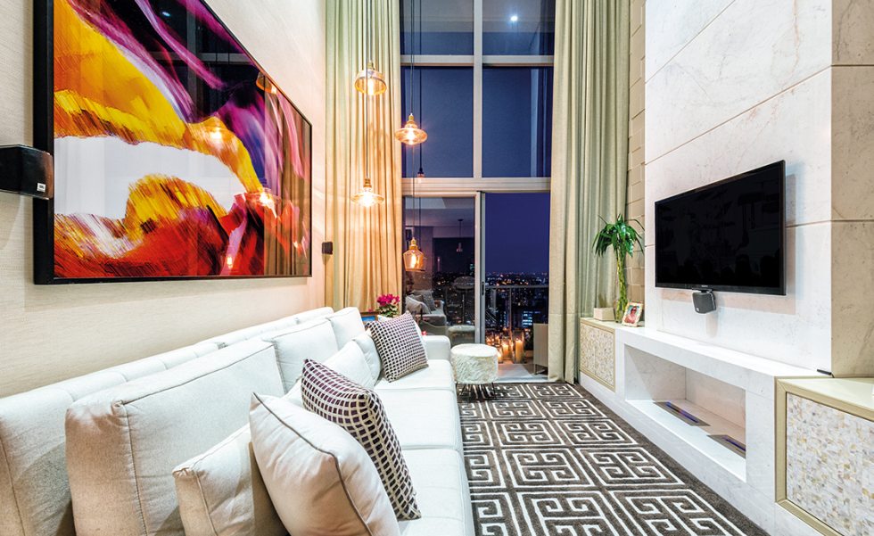A sala com pé direito duplo ganhou lareira com frontão em mármore Piguês e sofá Samui Touch (M. Decor). Pendentes decorativos e cortinas Hunter Douglas da M. Decor valorizam a amplitude do espaço A sala com pé direito duplo ganhou lareira com frontão em mármore Piguês e sofá Samui Touch (M. Decor). Pendentes decorativos e cortinas Hunter Douglas da M. Decor valorizam a amplitude do espaço