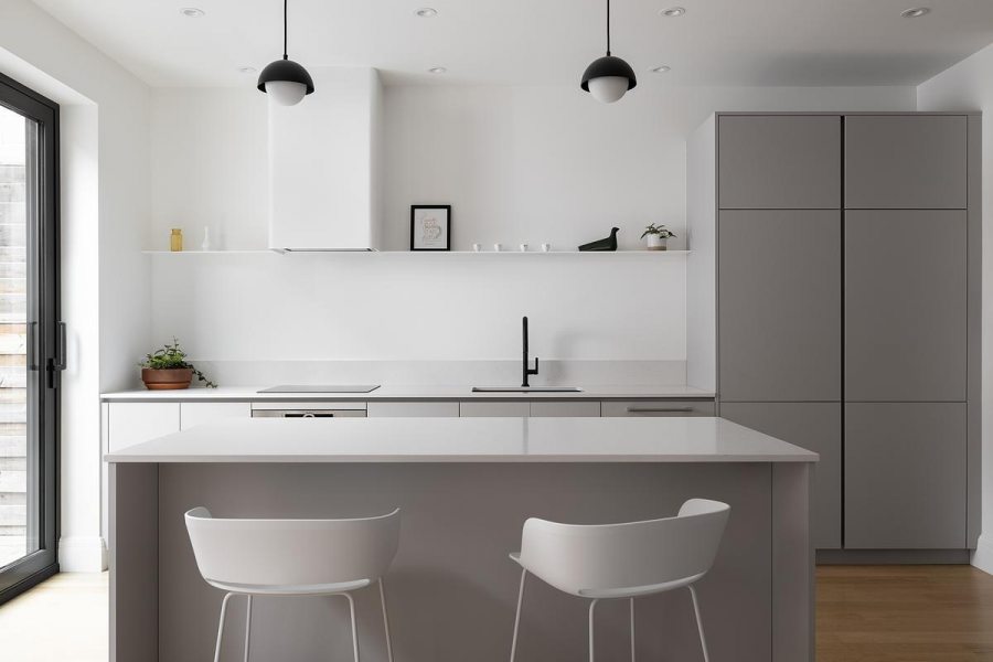 A base branca acompanha a marcenaria em tom neutro. O contraste aparece nos detalhes pretos e na madeira do piso. Projeto: Studio CRBN