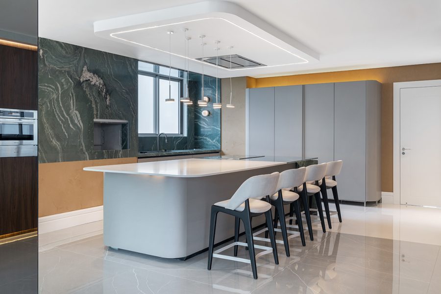 Na cozinha, uma ilha espaçosa organiza a circulação e reforça o encontro entre preparo e recepção.
