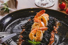 Spaghetti nero com gamberi e molho pomodoro.