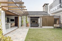 Projetada em formato ?L?, a casa se abre para um jardim interno que conecta cozinha e living através da varanda. 