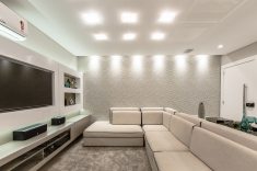 A sala de estar com hall de entrada ganhou um elegante sofá de linho e couro, selecionado a dedo na M. Decor, junto com o papel de parede 3D.
