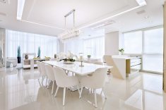 A mesa de jantar em laca branca (Villa Batel) acomoda até dez convidados. As cadeiras são da Saccaro Curitiba. Ao fundo, o living do apartamento