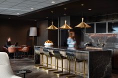 Na cozinha, madeira, bancada e iluminação pendente compõem um ambiente que também funciona como espaço de encontro.