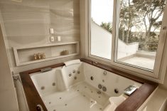 As persianas Luxaflex na janela e porta aumentam a privacidade. A Jacuzzi Aura Wood com borda em madeira foi posicionada para dar vista ao pequeno pátio e à paisagem externa.