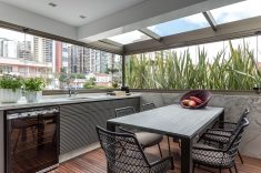 Para otimizar espaços, a sala de jantar passou a ocupar um dos terraços do apartamento (abaixo), dividindo o ambiente com a churrasqueira gourmet