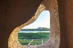 As paredes espessas e as aberturas irregulares criam uma experiência espacial que lembra cavernas, refúgios e ninhos.